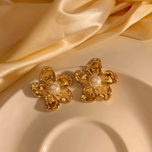 Elegant gold flower earrings with white pearls on premium champagne silk backdrop