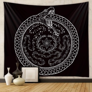Detail of bohemian black wall tapestry featuring white Ouroboros snake and celestial patterns