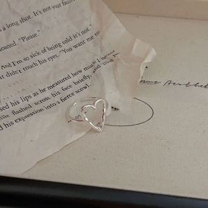 Minimalist 925 sterling silver hollow heart open ring on vintage newspaper background