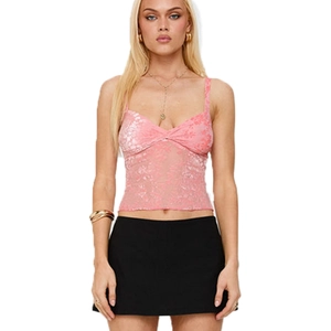 Top caraco en dentelle florale rose avec mini-jupe noire porté par un mannequin
