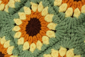 Macro shot of handcrafted crochet sunflower bag showing detailed yellow wool stitching