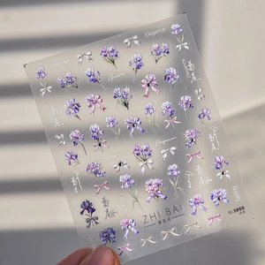 Detail of iris flower and bow nail stickers with shimmering metallic accents