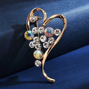 Detail of a heart-shaped gold brooch with sparkling crystals on deep blue velvet