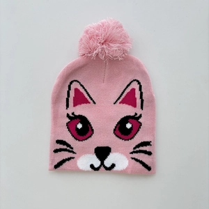 Detail of pink knitted hat with cartoon cat pattern and fluffy pom-pom top for kids