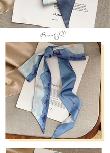 Macro shot of blue silk scarf featuring oil painting mountain print and love you text