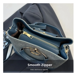 Close-up of smooth golden zipper and navy blue jacquard texture on the bucket bag