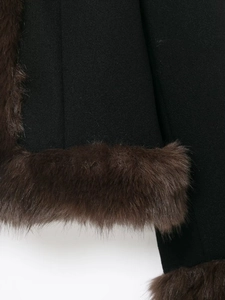 Detail of soft brown faux fur collar and cuffs on a black short stylish jacket
