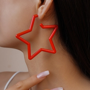 Gros plan d'une grande boucle d'oreille étoile rouge brillante portée par un mannequin