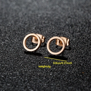 Minimalist rose gold stainless steel round stud earrings on a black display stand
