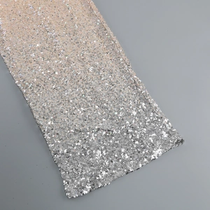 Detailed macro view of gradient champagne gold to silver sequin fabric and texture