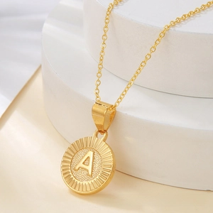 Detailed macro view of a gold circular alphabet A pendant with sunburst texture