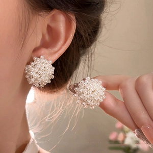 Close-up of elegant cluster pearl stud earrings worn to show vintage French style