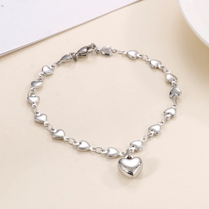 Close-up of silver heart-shaped necklace with multiple charms and lobster clasp