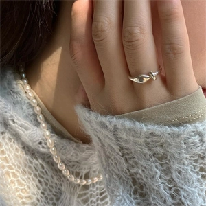 Minimalist 925 sterling silver knotted ring and delicate pearl necklace on a model