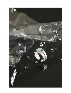 Macro detail of silver S925 ring with lava texture and bright blue zircon gemstone