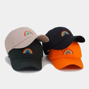 Detailed macro view of four colorful baseball caps with rainbow embroidery patterns