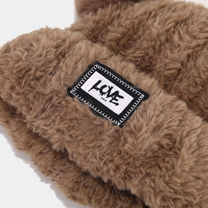 Gros plan du bonnet en peluche marron avec écusson brodé LOVE de style rétro