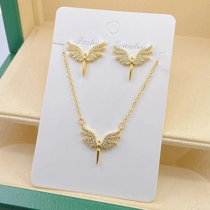 Close-up of golden angel wing jewelry set with rhinestones in a green gift box