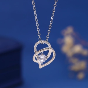 Macro shot of silver heart pendant with I Love You to the Moon and Back engraving