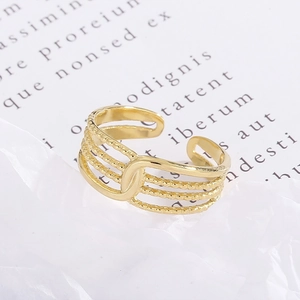 Macro detail of gold-plated multi-layer interlocking ring on textured white paper