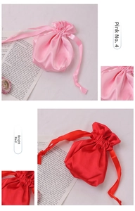Close-up of pink and red satin drawstring pouches with silky texture and ribbon ties