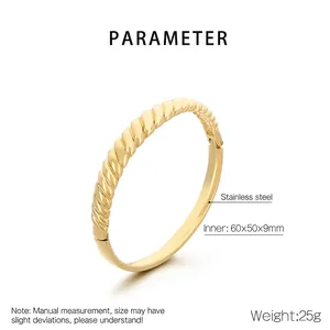 Detail of twisted cable gold stainless steel bangle with 60x50x9mm dimensions