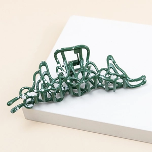 Green irregular liquid metal hair claw with white splatter on a minimalist white stand