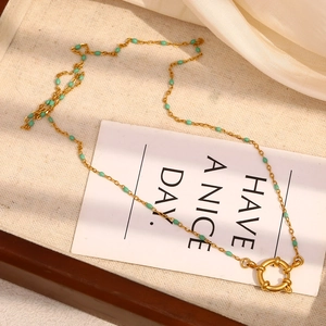 Detail of 18K gold-plated stainless steel necklace with green beads and spring ring