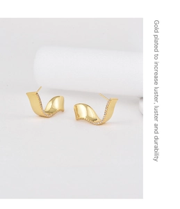 Detail view of gold-plated wavy earrings with sparkling micro-inlaid zirconia stones