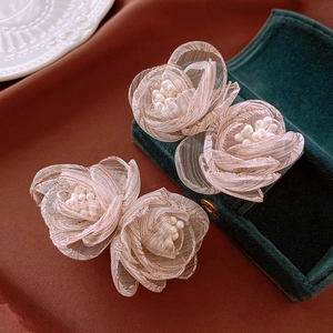 Elegant handmade lace flower earrings with pearls on a vintage silk background