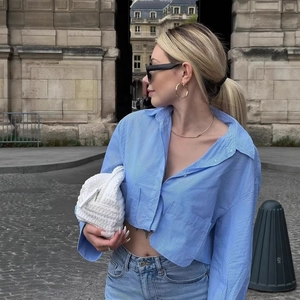 Chic blue striped cropped long sleeve shirt styled with light denim and a white woven bag