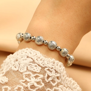 Detail of vintage metal beaded bracelet with sunburst patterns and retro silver finish