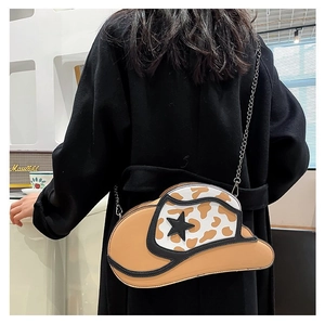 Detail of cowboy hat-shaped crossbody bag with star pattern and silver metal chain