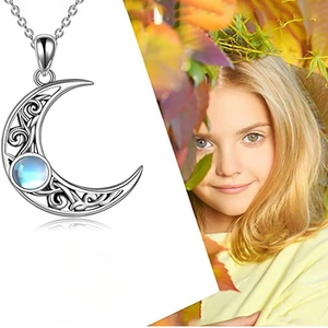 Detail of silver crescent moon necklace with moonstone inlay against a dreamy autumn backdrop