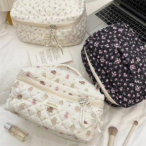 Detailed view of quilted cotton cosmetic bags in floral and cartoon bear patterns