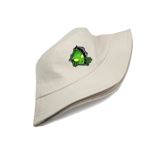 Détail de l'imprimé extraterrestre vert sur un chapeau bob en coton de couleur crème