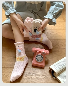 Détail de chaussettes en polaire corail rose avec motif animal mignon et décorations 3D