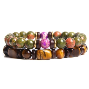 Detail of beaded bracelets featuring Tiger Eye stones and mixed green gemstones
