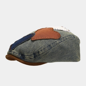 Detail of vintage denim beret with brown brim and retro patchwork stitching accents