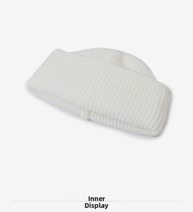 Detailed view of the ribbed knit texture and interior lining of the off-white beanie
