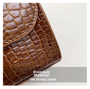 Détail de cuir marron foncé motif crocodile avec finition brillante et couture nette