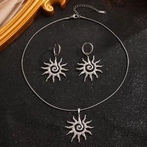 Detailed macro view of silver hollow sun pendant necklace and hoop earrings set
