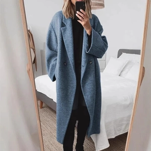 Détail de la texture d'un manteau long bleu en laine avec finition mélangée boutonnée
