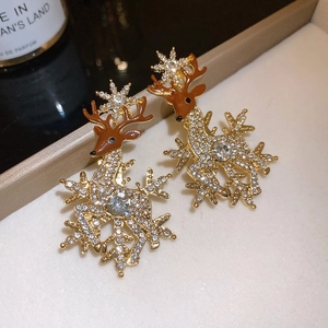 Macro shot of reindeer earrings with gold metal, white zircons and brown enamel detail