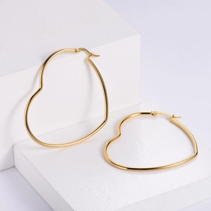 Polished golden titanium steel heart-shaped hoop earrings on minimalist display