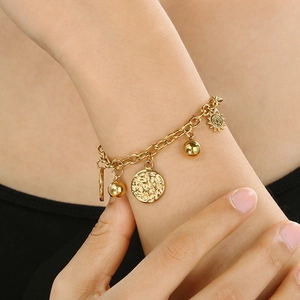 Minimalist gold stainless steel sun pendant bracelet with beads on a female model's wrist