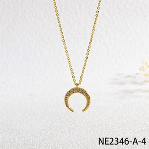 Macro shot of gold crescent necklace with micro-paved zircons on a textured background