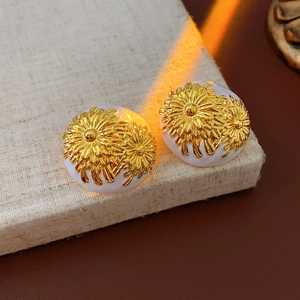 Detailed view of vintage-style round daisy earrings with golden floral embossing