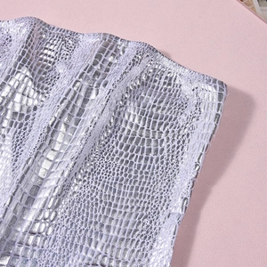Detail of silver metallic bandeau top with textured crocodile skin scale pattern