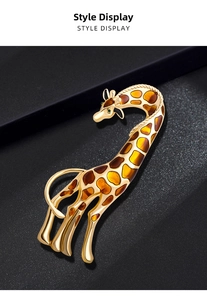 Macro shot of gold-plated giraffe brooch with colorful enamel patterns and green gem eye